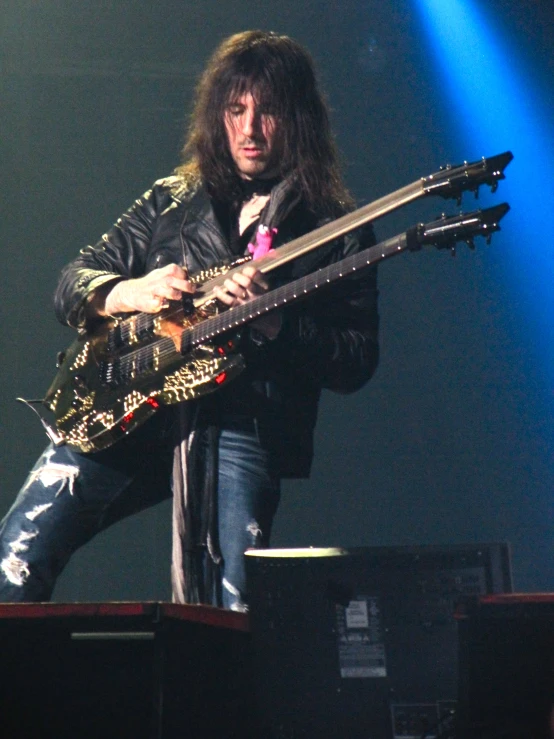 a male guitarist on stage playing a guitar