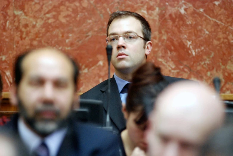 man sitting with microphone in middle of meeting area