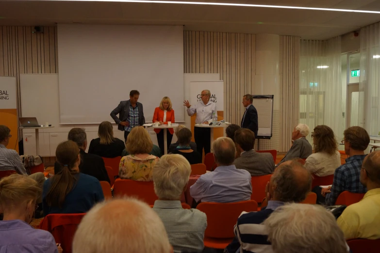 an audience of people watching a presenter at a conference