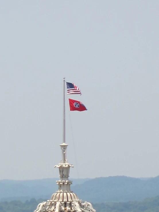 a flag flying from top of a large white building