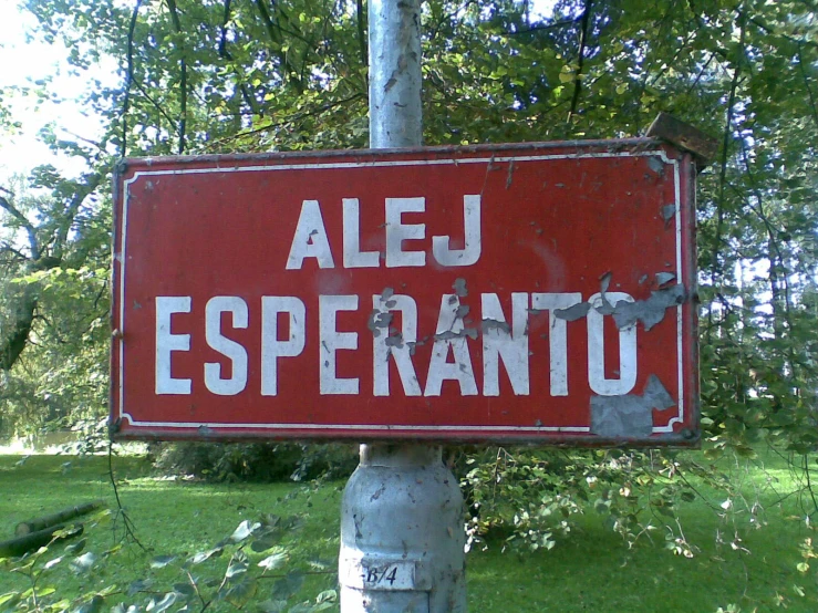 a red sign is hanging from a metal pole