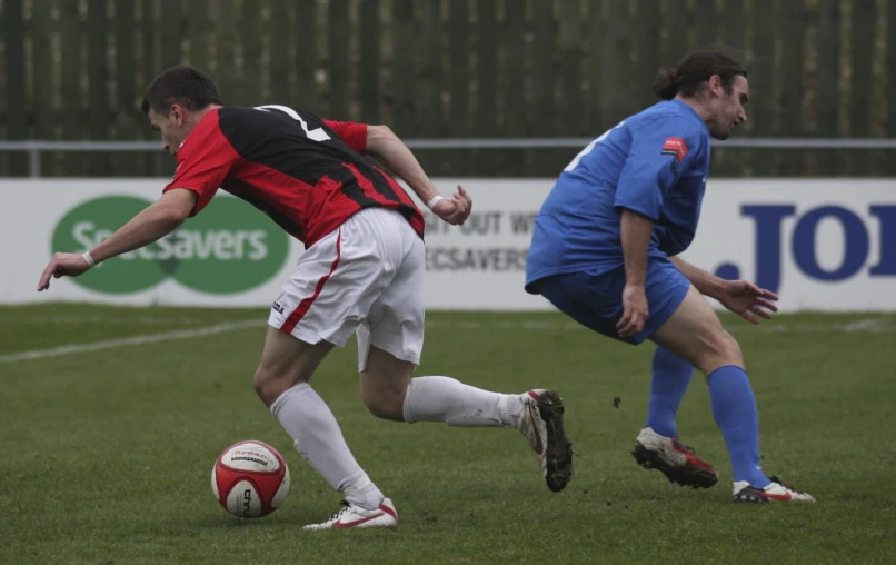 a group of men playing soccer on a grass field