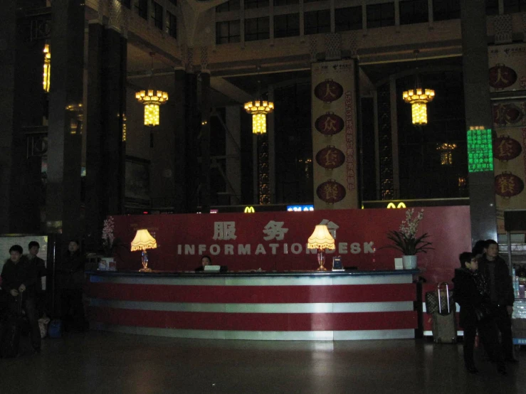 a lobby with an information desk surrounded by columns