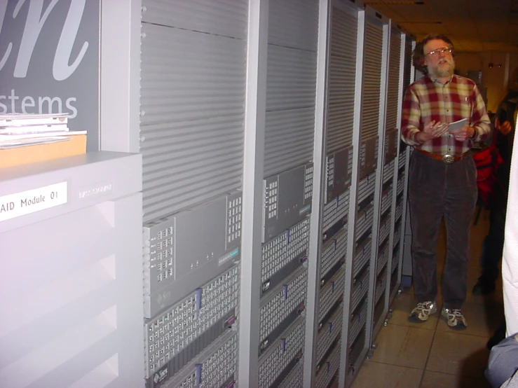 a man standing in front of many computer racks