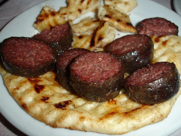 a white plate topped with lots of meat covered in sauce