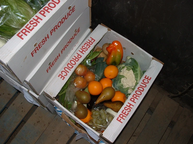 two boxes are stacked up next to some carrots