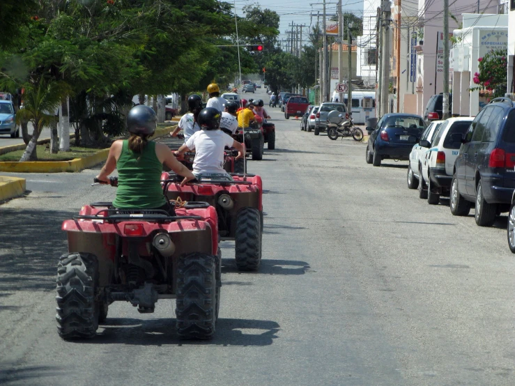 people riding four wheelers on the street