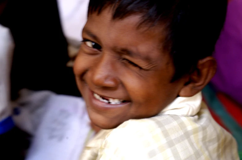 young child smiling for a portrait with others