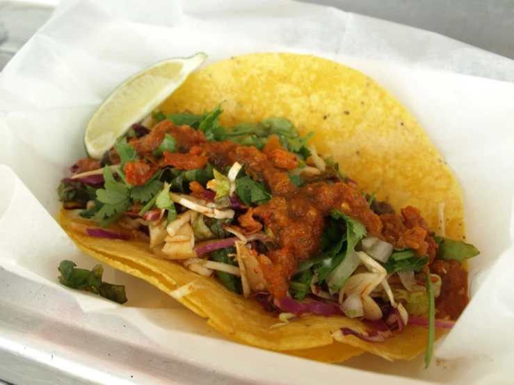 a taco in a plate with two chips