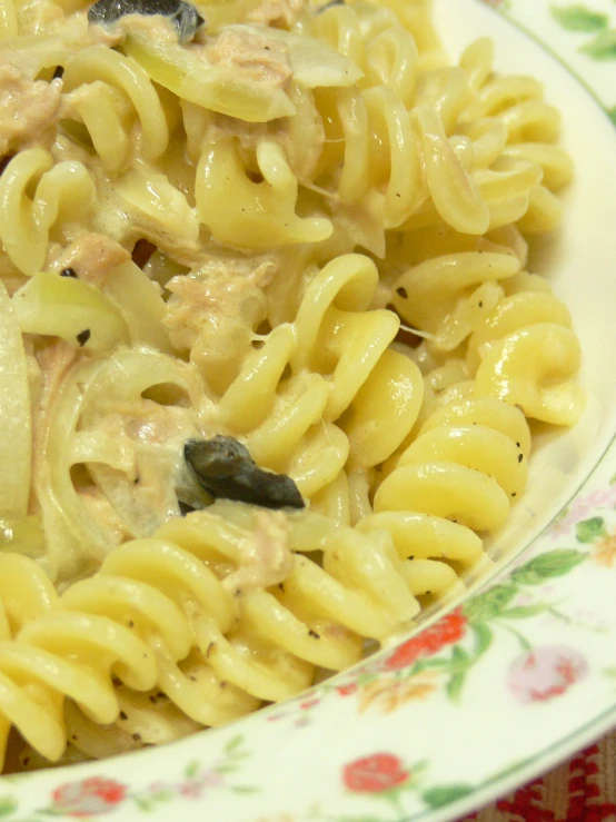 a close - up of a plate of pasta with onions and tuna