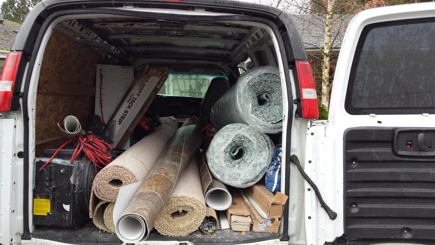 a truck with several rolls of firewood and hay