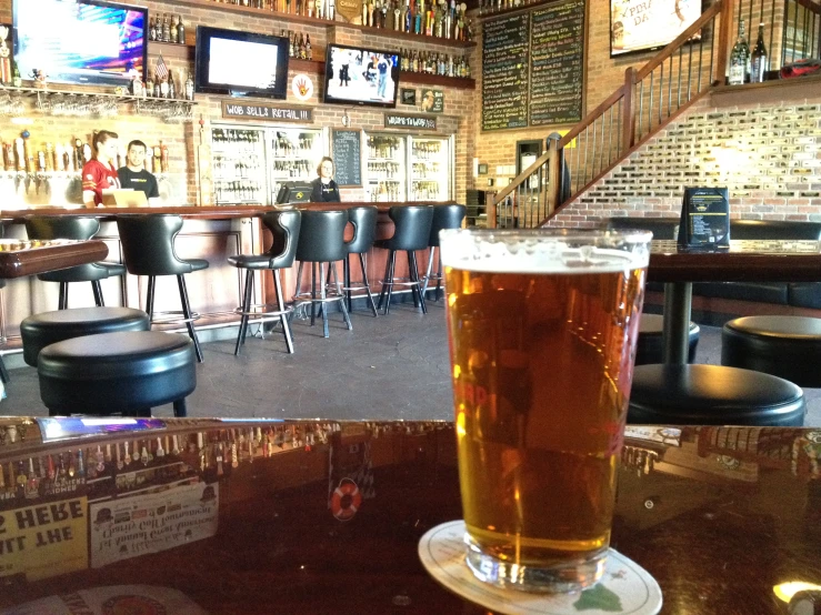 a pint of light ale sits on a table in the bar