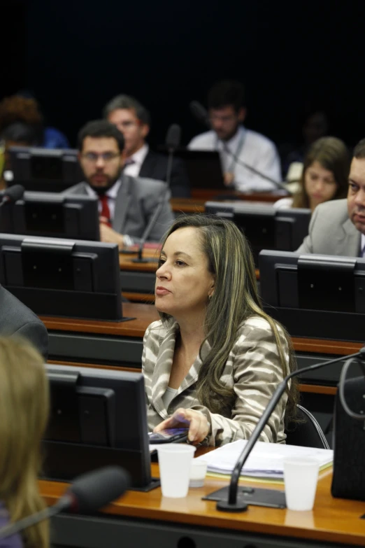 a woman in a black jacket sitting at a table with people