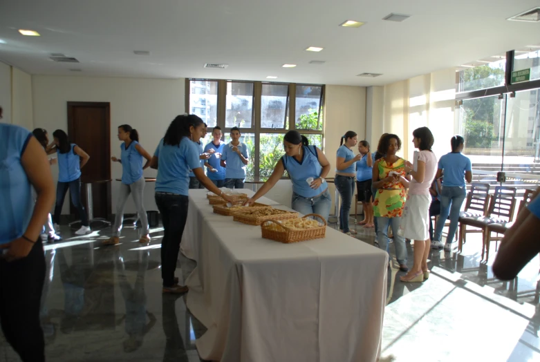 a group of people standing around tables that are filled with food