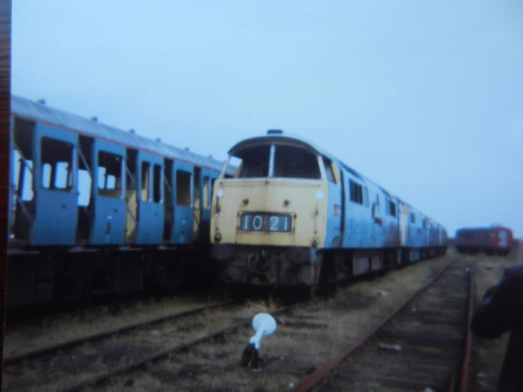 old and faded train cars on the tracks