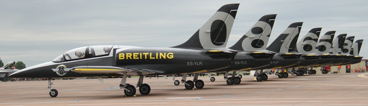 several black and white planes are parked in line