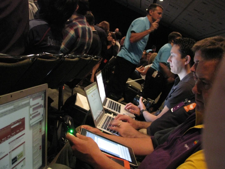 a group of men are using their laptops