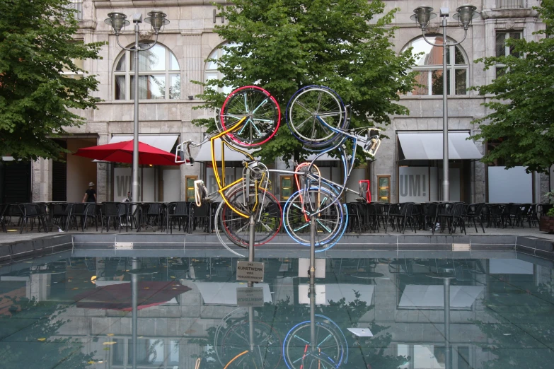 a sculpture with many rings in it sitting in a pool
