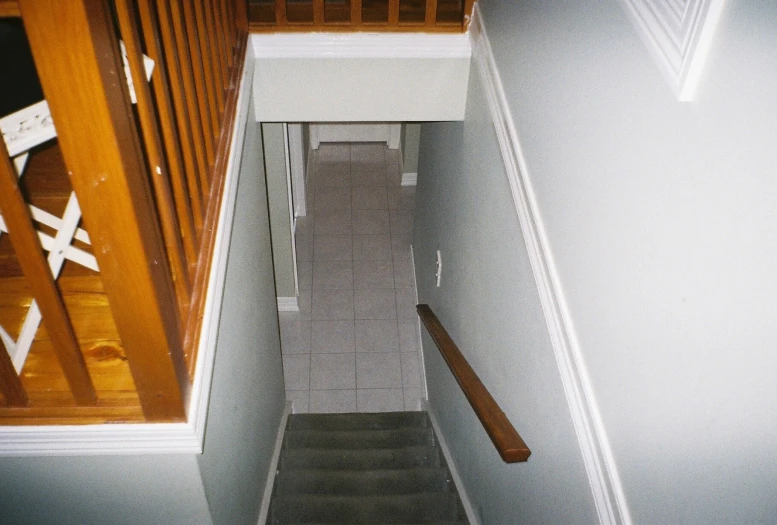 a po looking down a narrow corridor at a stair