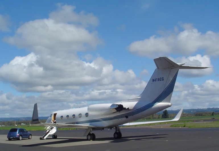 an airplane sitting in an airport runway with its door open