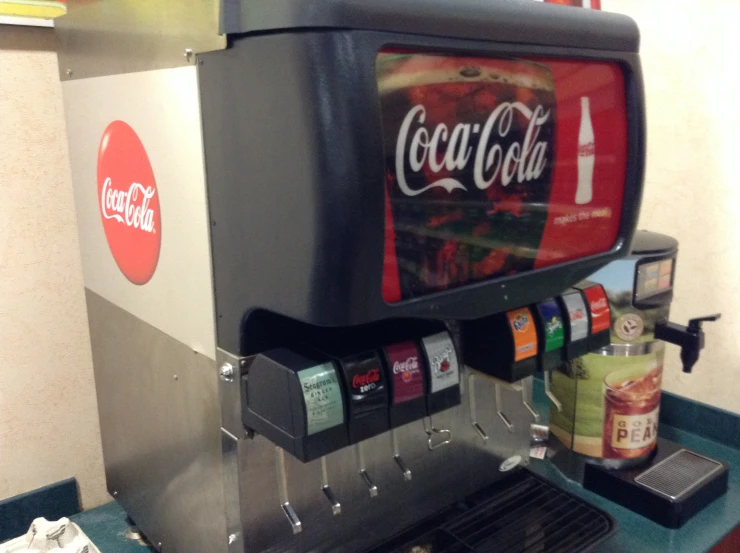 a machine with a coca - cola drink on it sitting on top of a counter