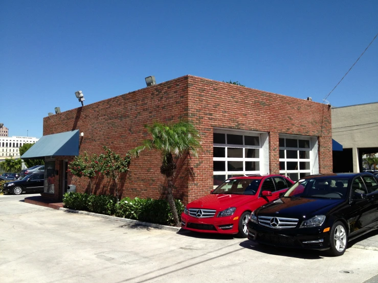 several parked cars outside a red brick restaurant