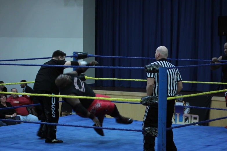 two boxers in the ring with referee standing behind them