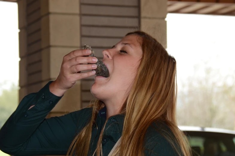 a woman drinking from her mouth and looking into the sky