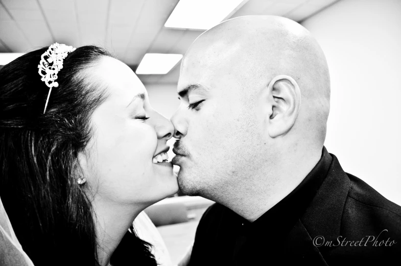 black and white image of a couple kissing