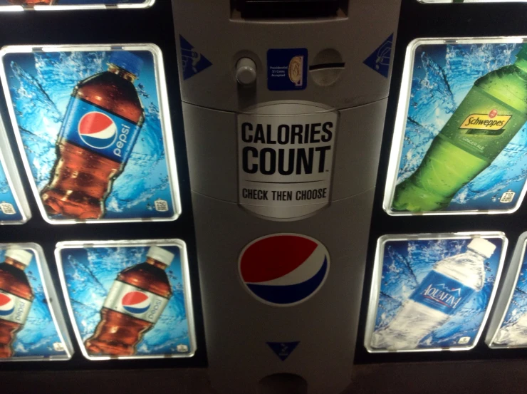 a close up of a soda machine with bottles of cola on display