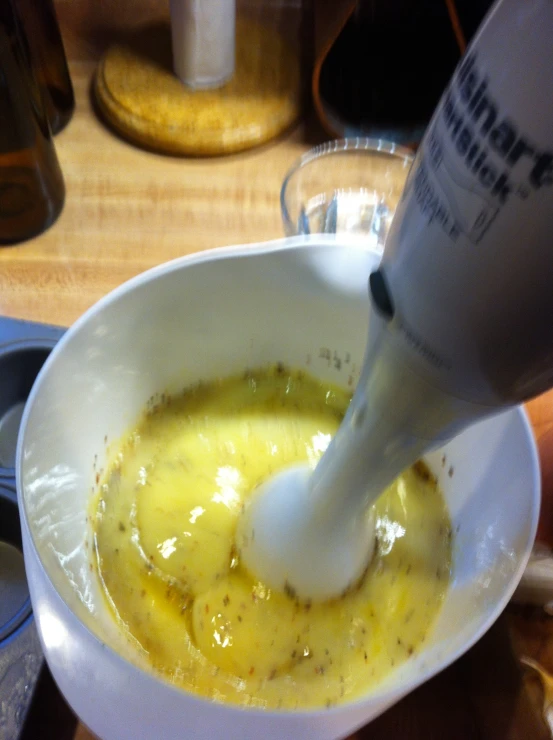 a person pouring white liquid into a white bowl