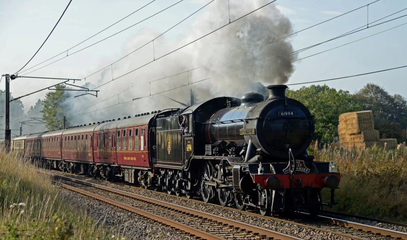 a steam train on tracks with smoke coming from it