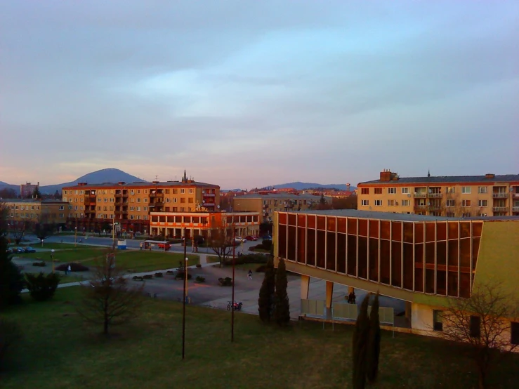 a view of the back of a building, with a few buildings around it