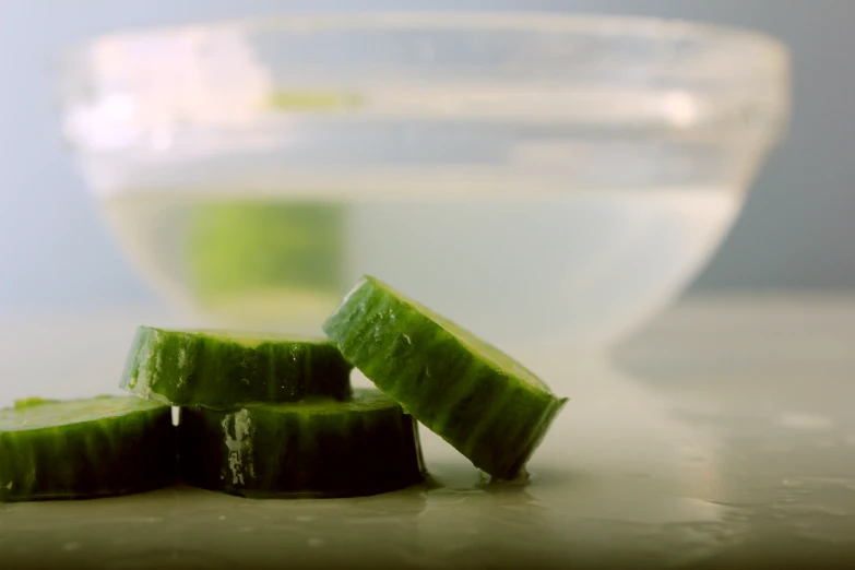 a bunch of cut up cucumbers sitting in front of some liquid