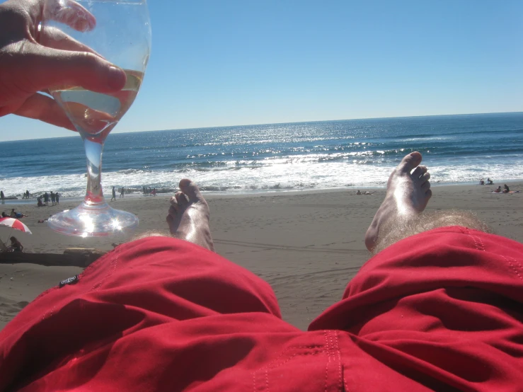 view of man's feet and a glass with champagne in his hand