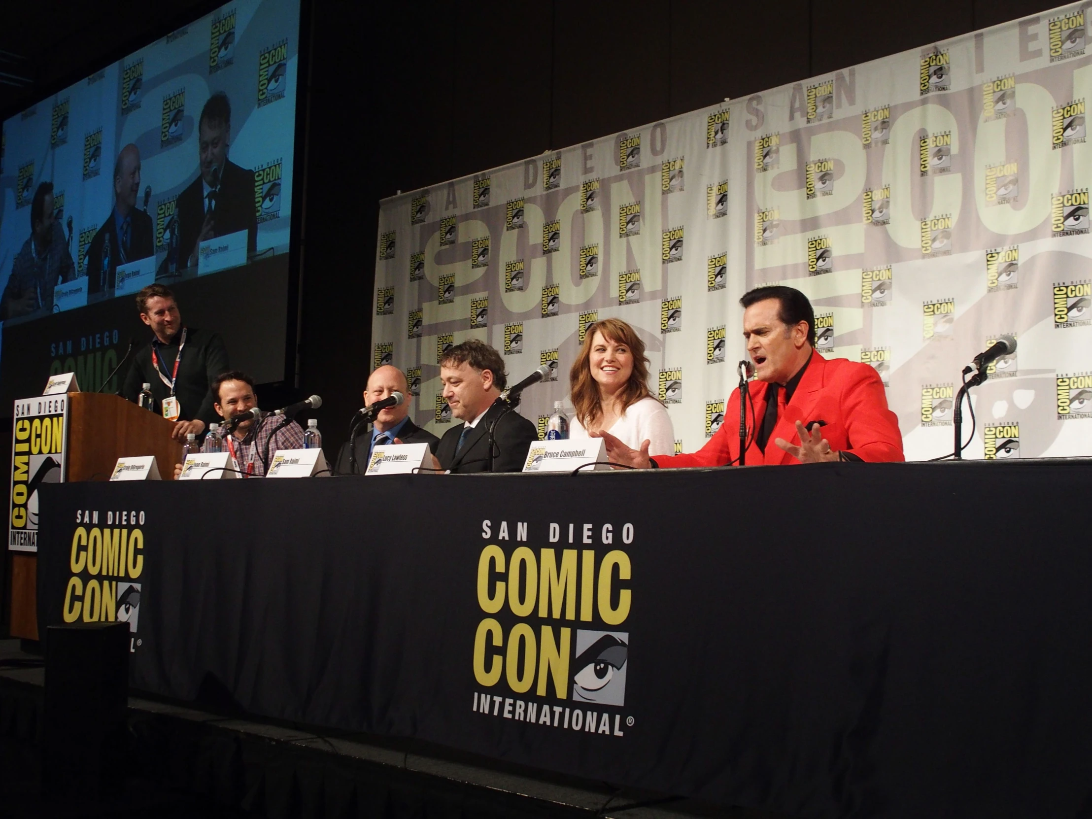 a panel of people sitting at tables talking