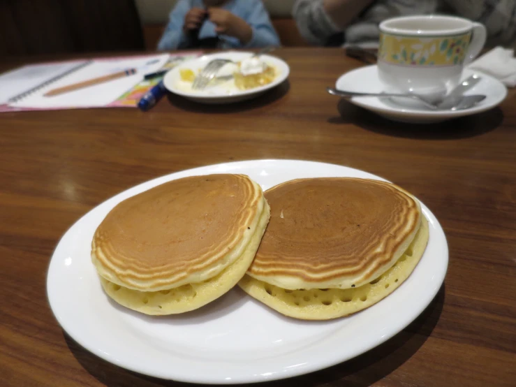 some pancakes that are on a plate near coffee