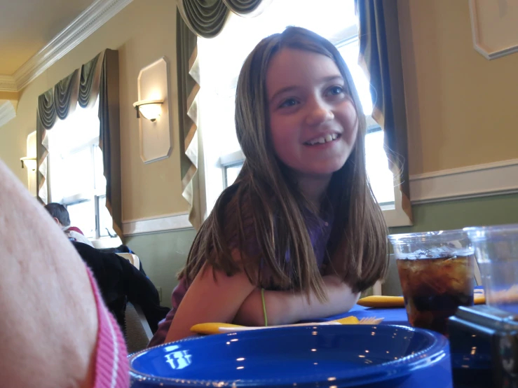 a  sitting at a table with a blue plate