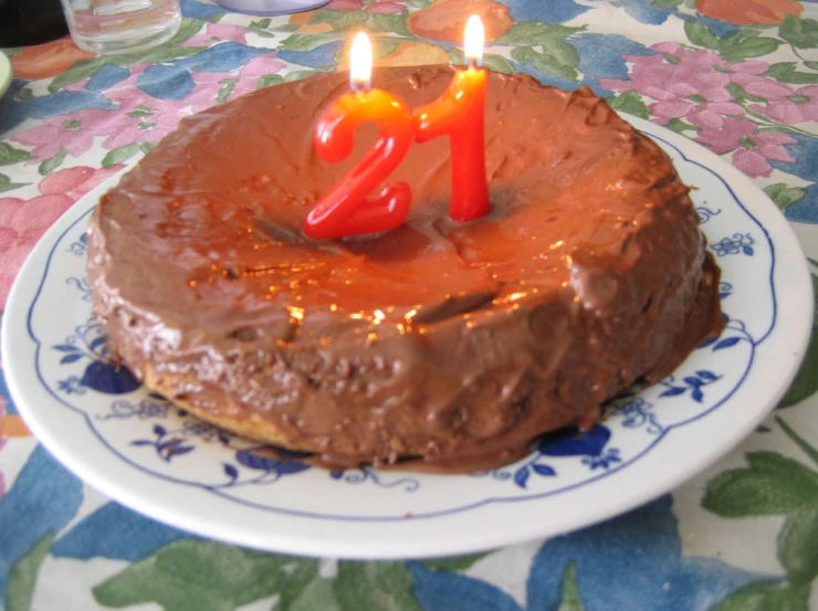 chocolate cake sitting on top of a table next to two candles