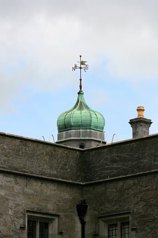 there is a green roof with a large sky in the background