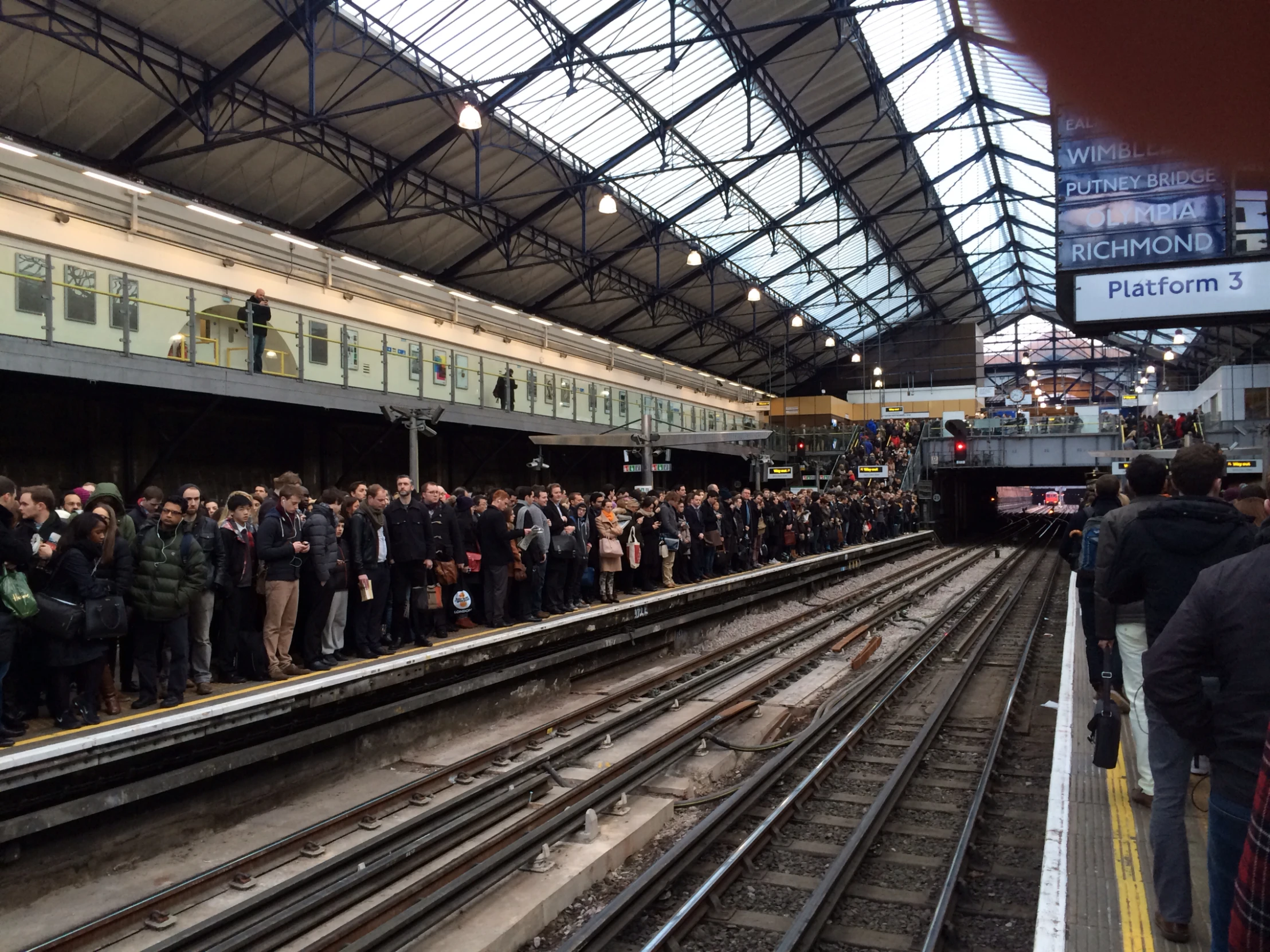 people standing on train tracks waiting for the train