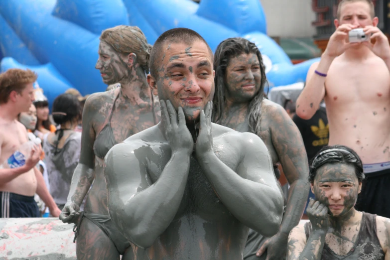 there are many people covered in mud, some are taking pictures