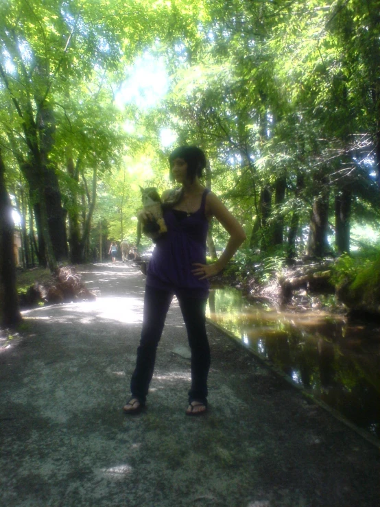 a woman standing on a walkway holding soing in her hand