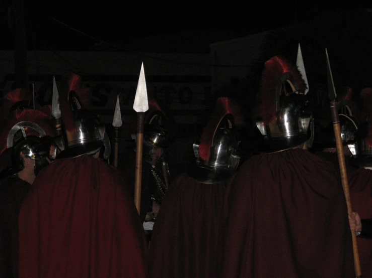 a bunch of guys with helmets that are wearing swords