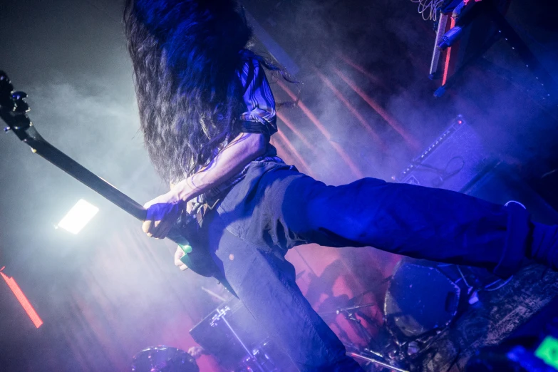 a man playing a guitar while standing on top of a stage