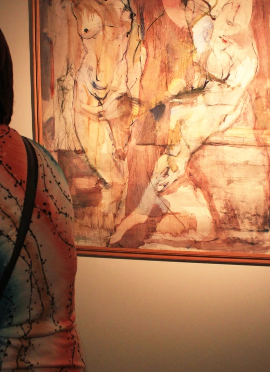 woman looking at an art work hanging in a gallery