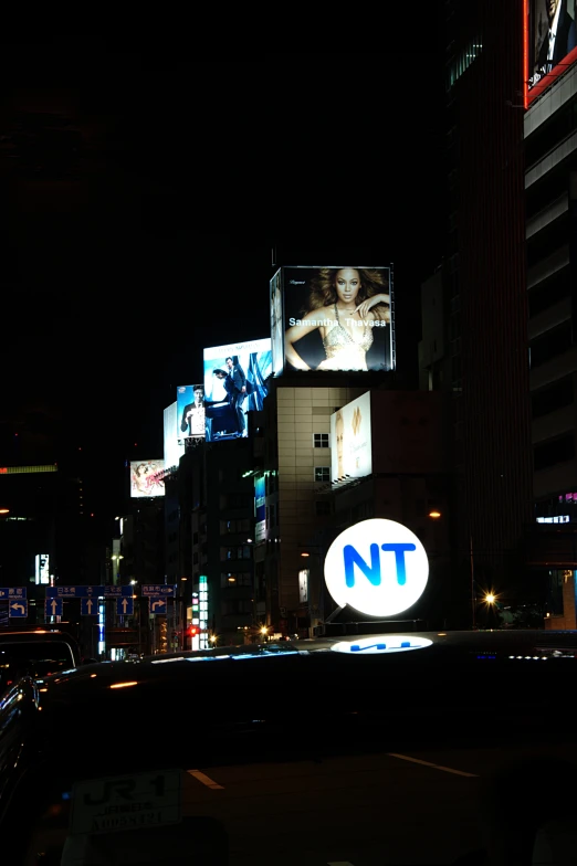 street signs are lit up at night on a building facade