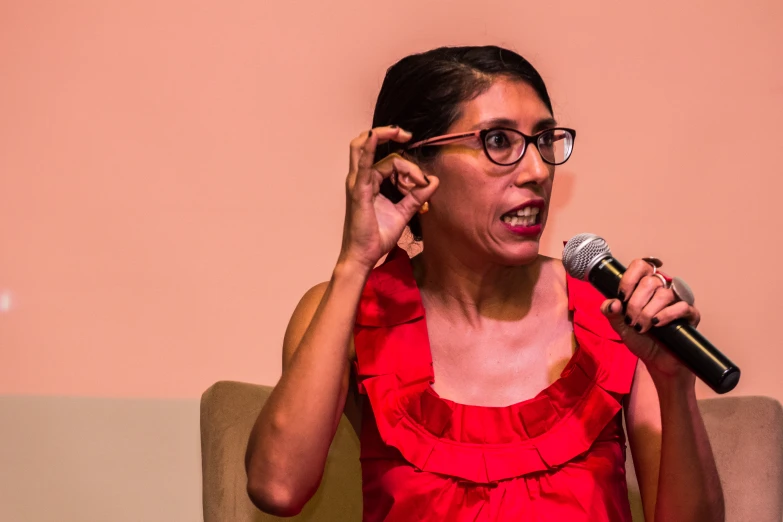 woman in red dress holding up a microphone