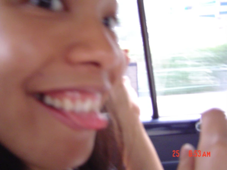 a young woman smiles as she sits in a bus