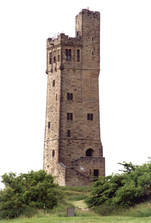 a very tall brick building that is built on top of some grass